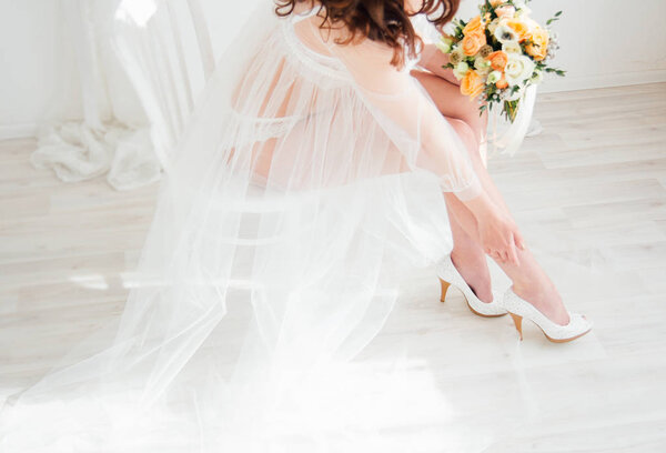 Boudoir bride's morning. Young beautiful woman with a bouquet in a negligee preparing for their wedding day. Toning.