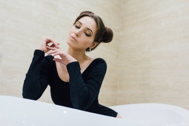 Kadın banyoda siyah bir elbise