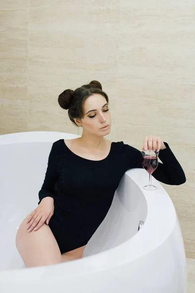 Woman in a black bodysuit in the bathroom — Stock Photo, Image