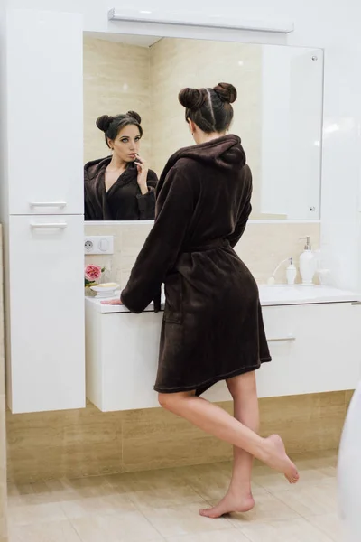 Frau im braunen Bademantel im Badezimmer — Stockfoto