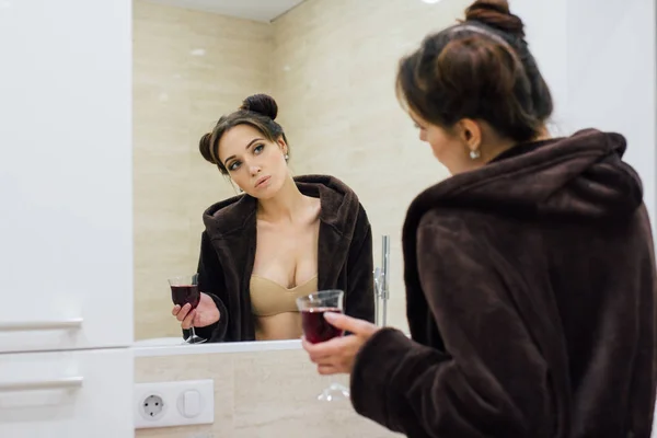 Женщина в коричневом удобном халате в ванной комнате — стоковое фото