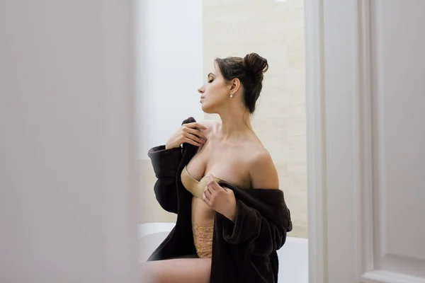 Nő-egy barna kényelmes fürdőköpeny, a fürdőszobában — Stock Fotó
