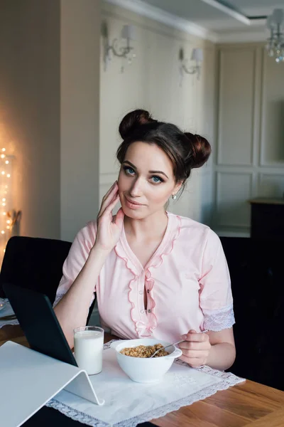 Жінка снідає з крупами і молоком і дивиться на планшет — стокове фото