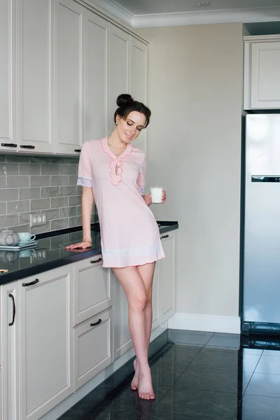 Mujer en la cocina sosteniendo un vaso de leche — Foto de Stock