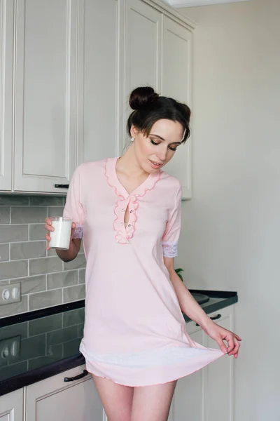 Женщина на кухне держит стакан молока — стоковое фото