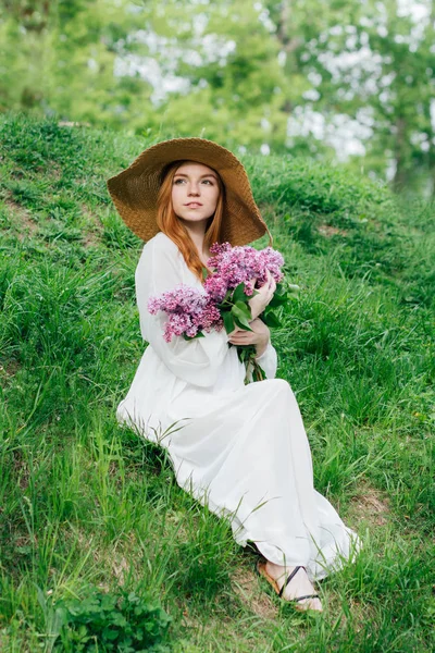 Kızıl saçlı kız leylak bahar bahçe içinde bir buket