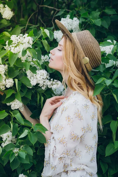 Blonde Frau mit lila Blüten im Frühling — Stockfoto