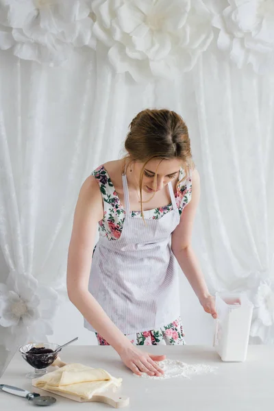 Nuori kaunis nainen valmistelee kotitekoisia croissanteja — kuvapankkivalokuva
