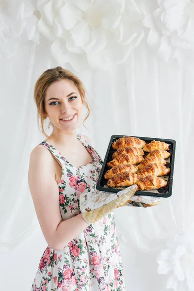 Ung smuk kvinde forbereder hjemmelavede croissanter - Stock-foto