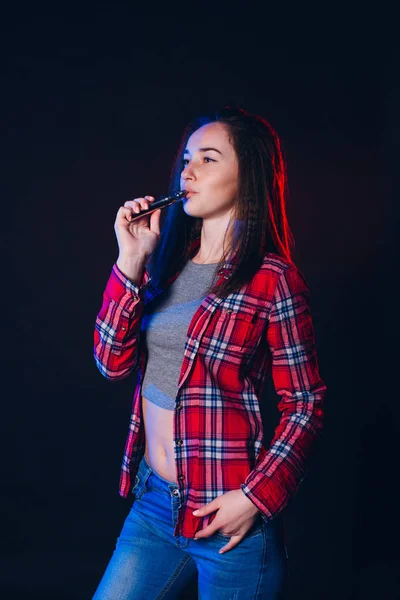 Женщина курит электронную сигарету с дымом — стоковое фото
