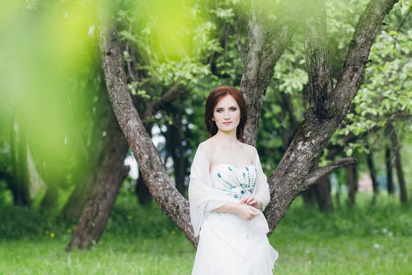 Yaz bahçesinde uzun beyaz elbiseli kadın 