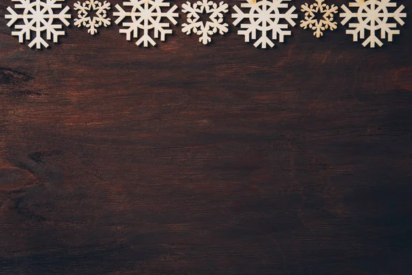 Karanlık bir arka plan üzerinde ahşap kar taneleri