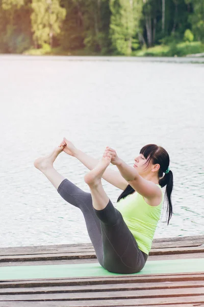 Wanita melakukan yoga di jembatan di musim panas — Stok Foto