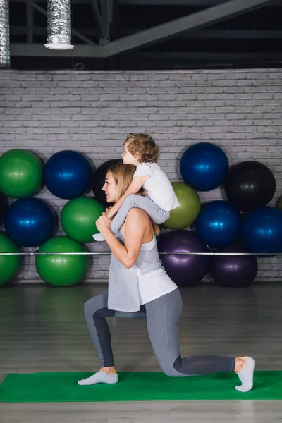 Μητέρα και μωρό κορίτσι κάνει ασκήσεις μαζί στο γυμναστήριο — Φωτογραφία Αρχείου