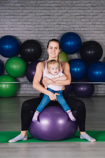 Anne ve bebek kız yapmak egzersizleri birlikte spor salonunda — Stok fotoğraf