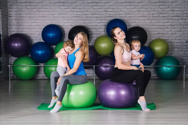 İki genç spor anne ve bebek kız yapmak egzersizleri birlikte