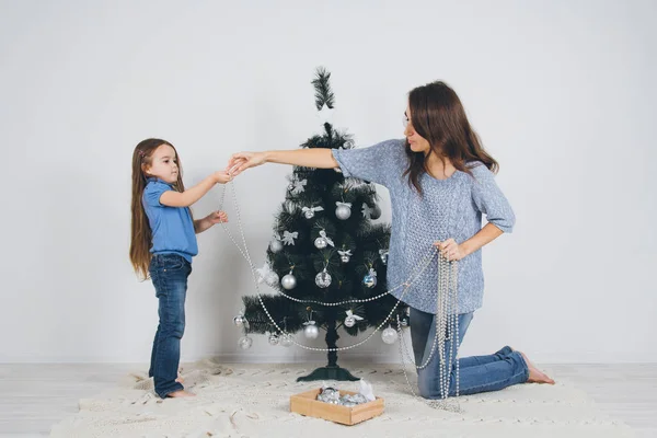 Mor och dotter dekorera julgran — Stockfoto