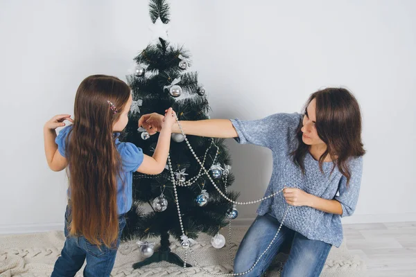 Mor och dotter dekorera julgran — Stockfoto