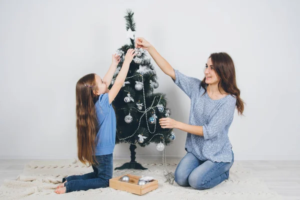 Mor och dotter dekorera julgran — Stockfoto