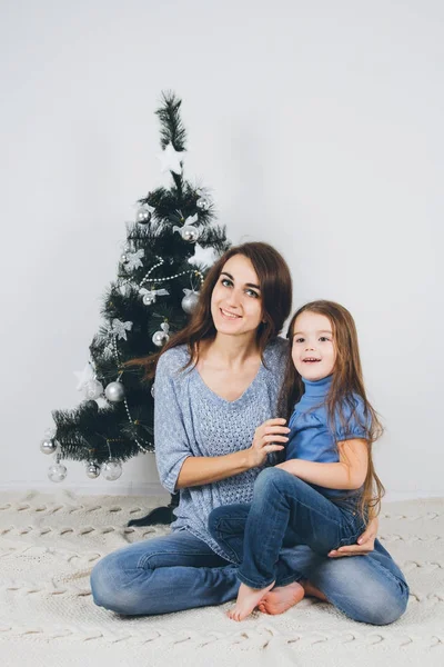 Mor och dotter dekorera julgran — Stockfoto
