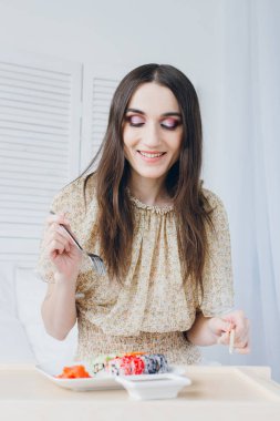 Kadın seçer elinde çatal ve yemek çubukları. 