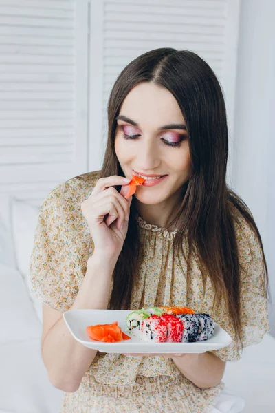 Joven morena comiendo sushi — Foto de Stock
