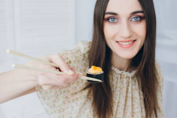 Młoda brunetka kobieta jedzenie sushi — Zdjęcie stockowe