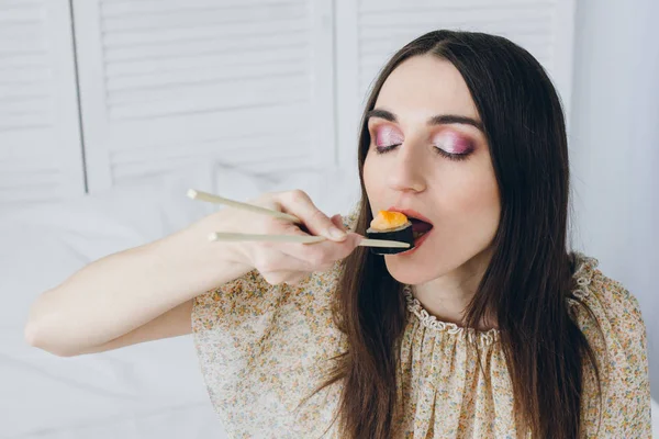 Joven morena comiendo sushi — Foto de Stock