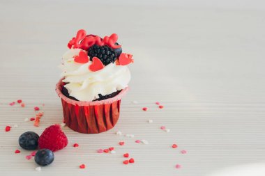 Beyaz krema, taze meyveler ve dekorasyon ile cupcakes