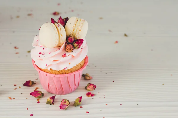 Pembe krema, macaroons ve gül ile cupcakes 