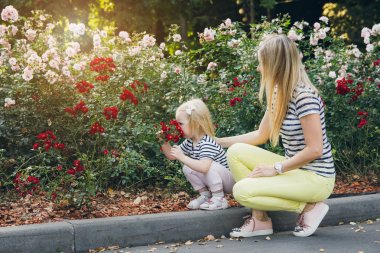 Genç güzel anne ve Gül kokulu küçük bir kız 