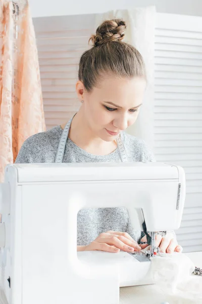 Joven costurera que trabaja en la máquina de coser — Foto de Stock