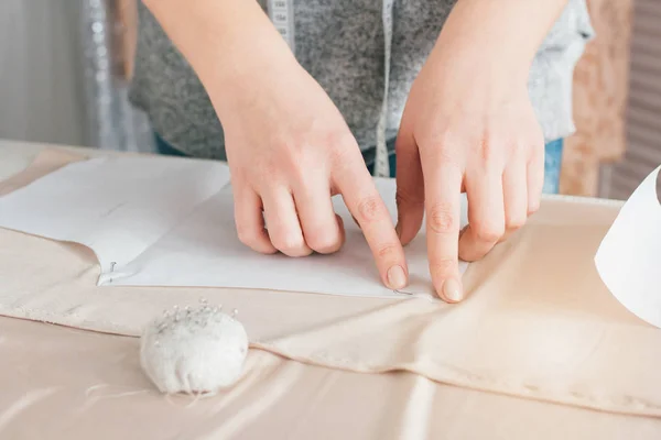 Joven costurera hace que la ropa corte tela — Foto de Stock