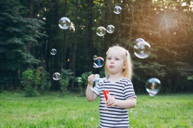 Küçük kız şişirmek sabun köpüğü'nın bahçesinde
