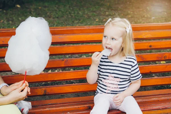 Mother and little daughter eating cotton candy — Stock Photo, Image