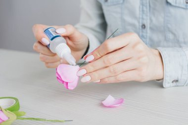 Çiçekçi Foamiran 'dan yapay çiçeklerle çelenk yapıyor.