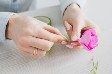 Çiçekçi Foamiran 'dan yapay çiçeklerle çelenk yapıyor.