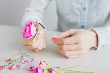 Çiçekçi Foamiran 'dan yapay çiçeklerle çelenk yapıyor.