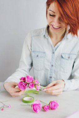 Çiçekçi Foamiran 'dan yapay çiçeklerle çelenk yapıyor.