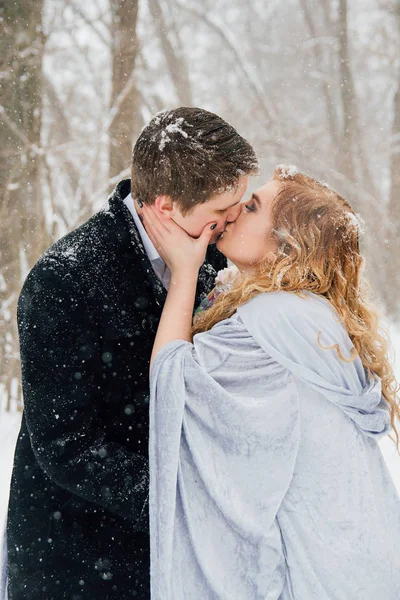 Casal na natureza no inverno durante uma queda de neve — Fotografia de Stock