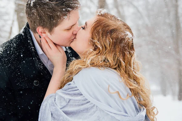 Casal na natureza no inverno durante uma queda de neve — Fotografia de Stock