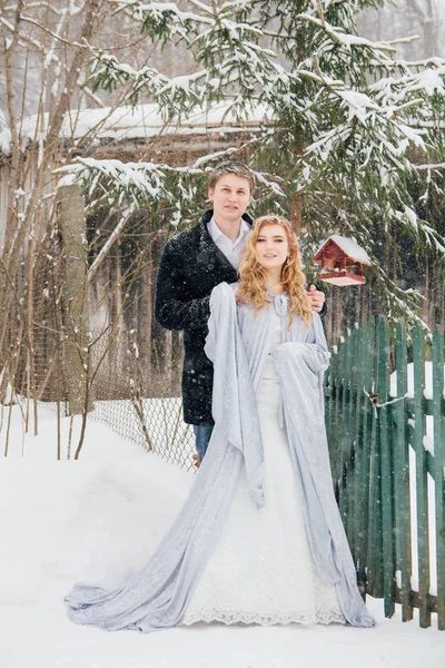 Casal na natureza no inverno durante uma queda de neve — Fotografia de Stock