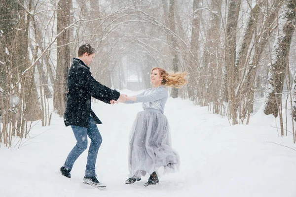 Pareja en la naturaleza en invierno durante una nevada — Foto de Stock