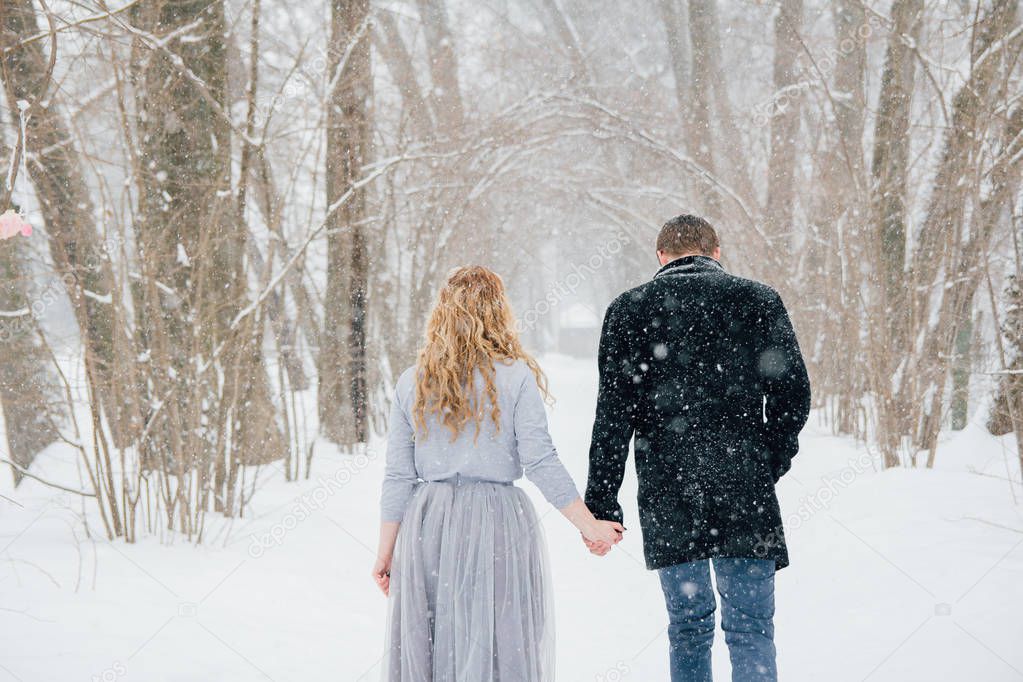 Couple on nature in winter during a snowfall