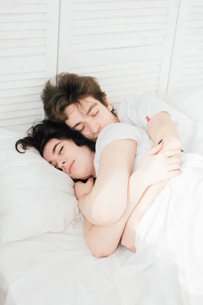 Пара влюбленных спит обнимаясь в постели — стоковое фото
