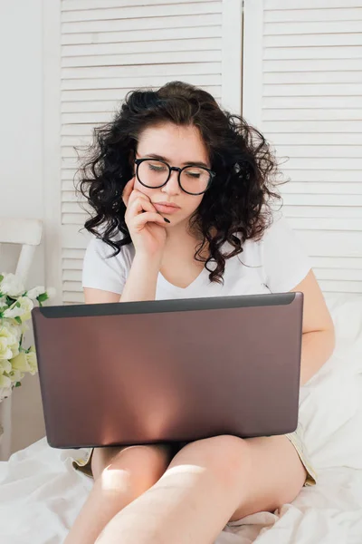 Menina na cama trabalhando em um laptop — Fotografia de Stock