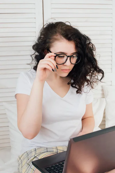 Menina na cama trabalhando em um laptop — Fotografia de Stock