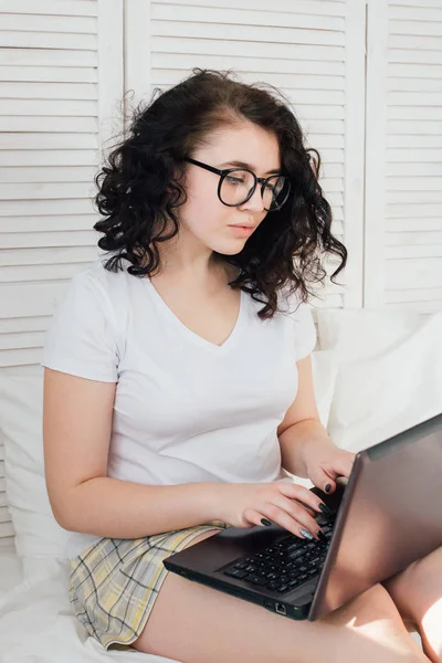 Menina na cama trabalhando em um laptop — Fotografia de Stock