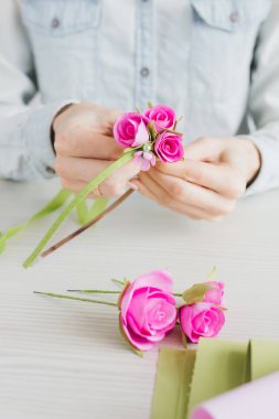 Çiçekçi Foamiran 'dan yapay çiçeklerle çelenk yapıyor.