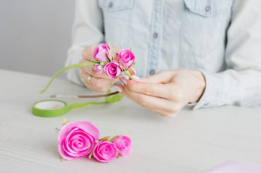 Çiçekçi Foamiran 'dan yapay çiçeklerle çelenk yapıyor.